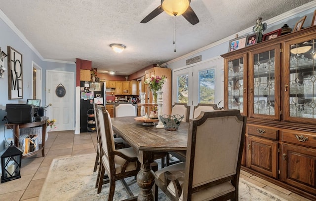 dining room with light tile patterned floors, ceiling fan, ornamental molding, and a textured ceiling