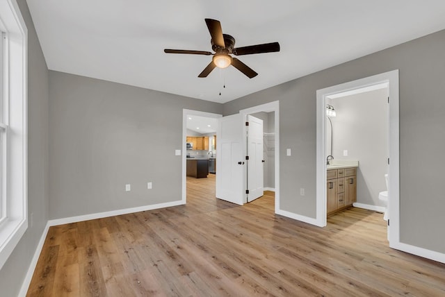 unfurnished bedroom featuring baseboards, a walk in closet, and light wood-style floors