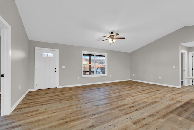 entrance foyer featuring vaulted ceiling, ceiling fan, light wood-style flooring, and baseboards