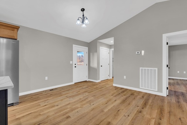 unfurnished dining area featuring lofted ceiling, light wood-type flooring, visible vents, and baseboards