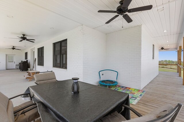 wooden terrace with ceiling fan and outdoor dining area