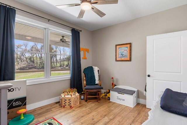 rec room featuring light wood-style floors, ceiling fan, and baseboards