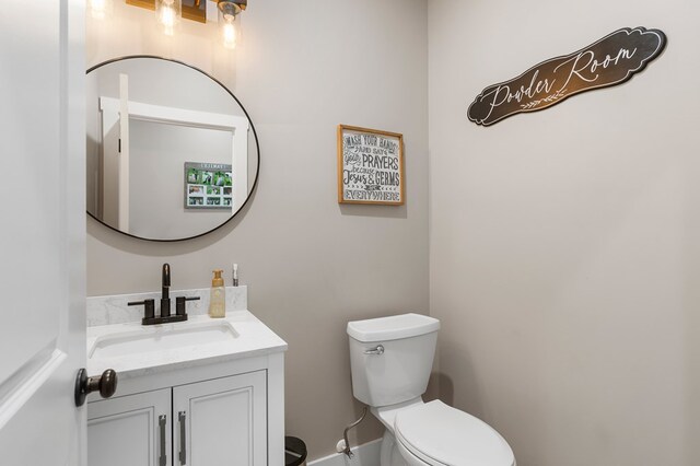 half bath featuring toilet and vanity