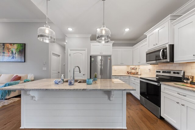 kitchen with white cabinetry, appliances with stainless steel finishes, crown molding, and decorative light fixtures