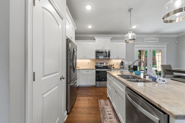 kitchen with crown molding, stainless steel appliances, a sink, and white cabinets