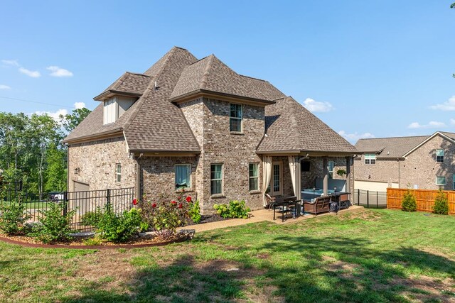 back of property featuring a shingled roof, a fenced backyard, a yard, a patio area, and brick siding