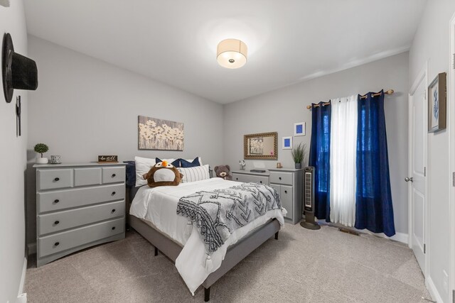 bedroom with baseboards and light colored carpet