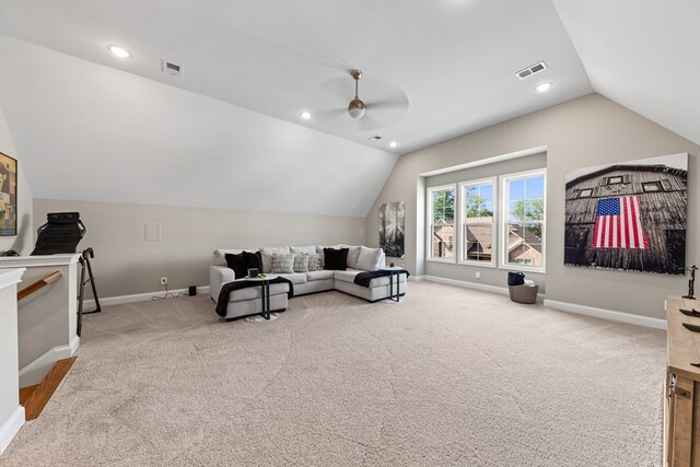 carpeted living area with lofted ceiling, visible vents, and baseboards