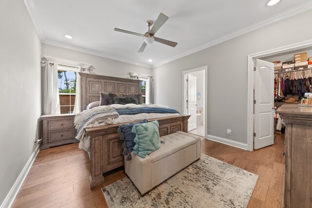 bedroom with baseboards, light wood-style flooring, a spacious closet, crown molding, and recessed lighting