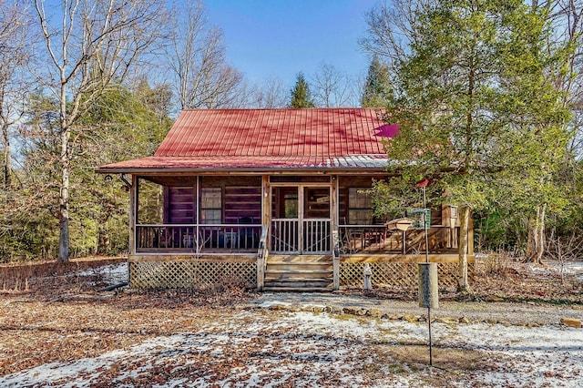 chalet / cabin featuring covered porch and metal roof