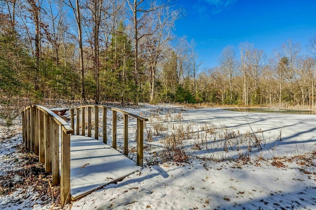 snow covered pool featuring a view of trees