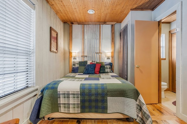 bedroom with light wood-style floors and wood ceiling