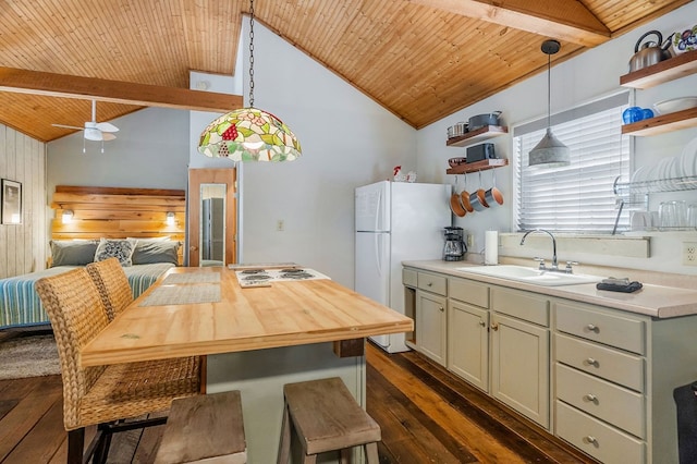 kitchen featuring pendant lighting, light countertops, a sink, and open shelves