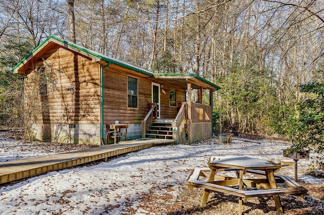 snow covered rear of property with crawl space