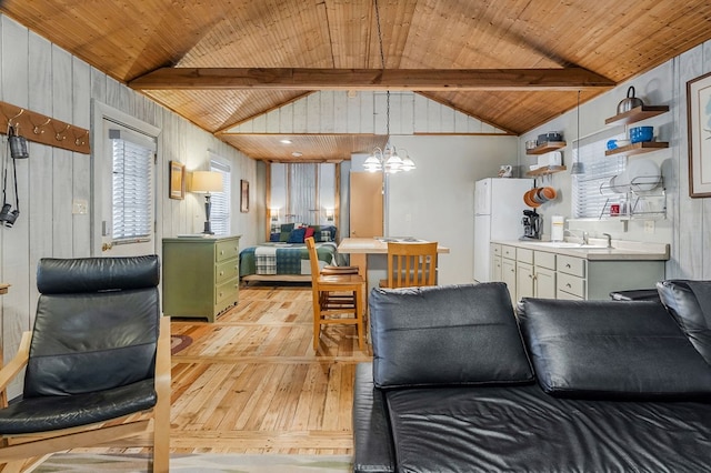 interior space with lofted ceiling with beams, light wood finished floors, wood ceiling, and an inviting chandelier