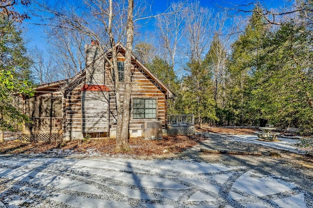 snow covered property featuring crawl space, a chimney, and a deck