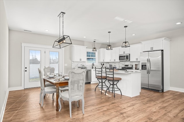 dining area with recessed lighting, visible vents, baseboards, and light wood finished floors