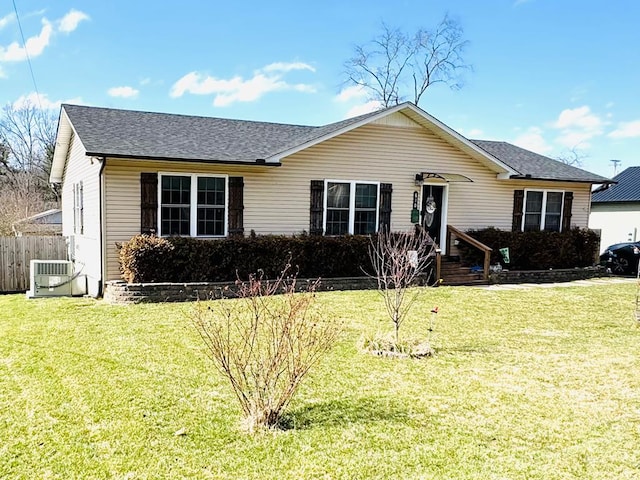 ranch-style house featuring central AC unit, a front yard, fence, and a shingled roof