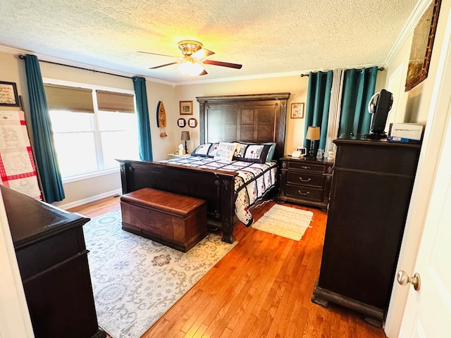 bedroom with ornamental molding, a ceiling fan, a textured ceiling, and wood finished floors