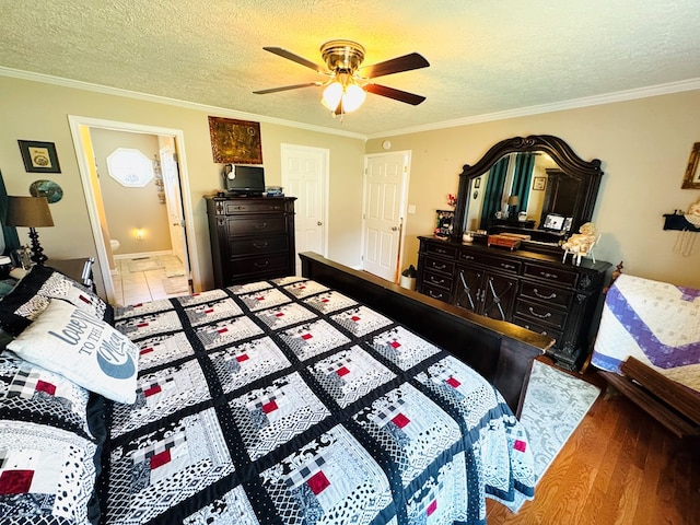 bedroom featuring a textured ceiling, ceiling fan, wood finished floors, and crown molding