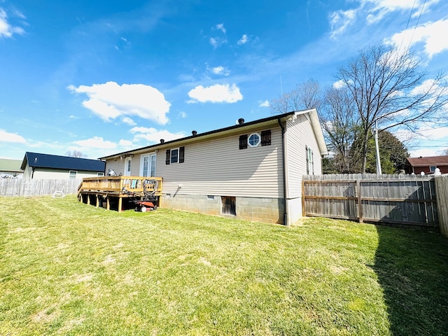 back of house featuring a fenced backyard, a lawn, and a deck