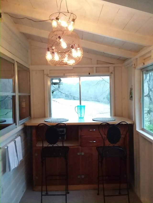 interior space featuring vaulted ceiling with beams and a chandelier