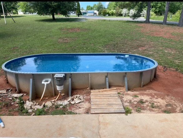 outdoor pool featuring a lawn