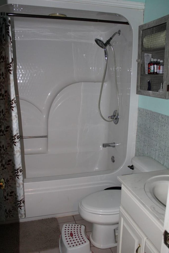 full bath featuring toilet, vanity, tile patterned flooring, and shower / bath combo with shower curtain