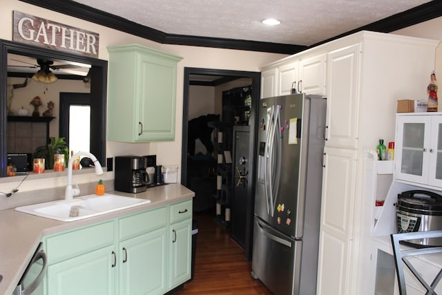 kitchen with light countertops, appliances with stainless steel finishes, dark wood-type flooring, a sink, and a textured ceiling