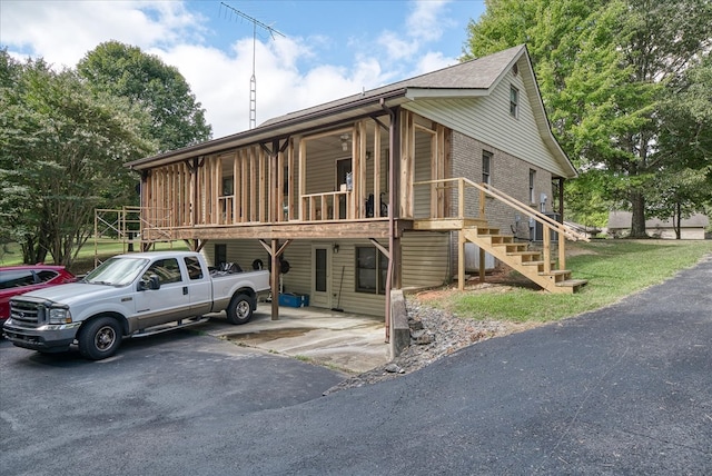 view of front of home with brick siding, stairway, and aphalt driveway