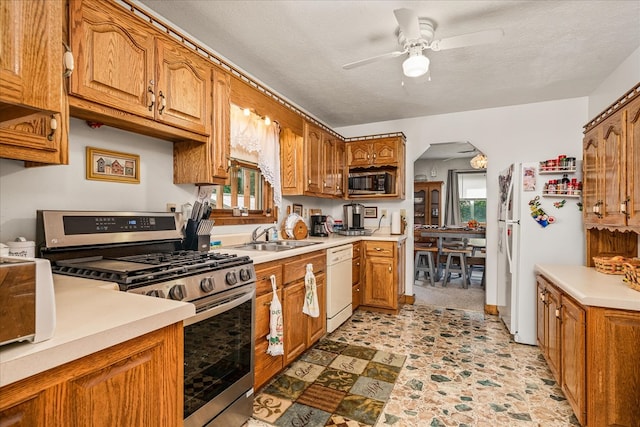 kitchen featuring a sink, brown cabinetry, stainless steel appliances, and light countertops