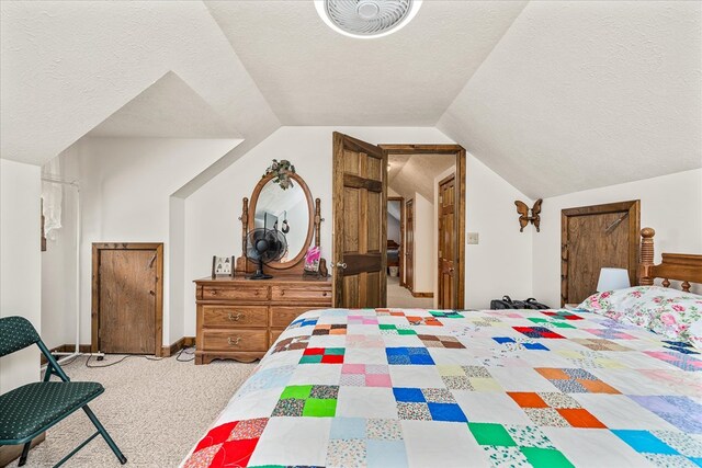 bedroom featuring lofted ceiling, visible vents, light colored carpet, and a textured ceiling