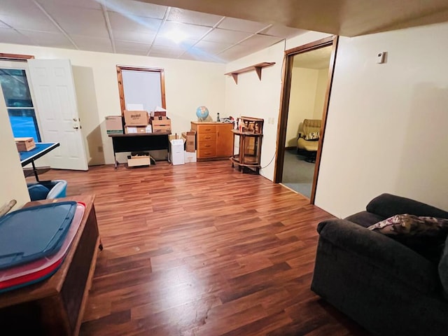 interior space with a drop ceiling and wood finished floors