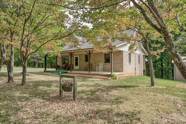 view of front of home with brick siding, a front lawn, and a patio