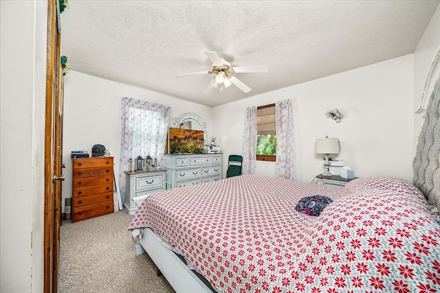 bedroom with light carpet, ceiling fan, multiple windows, and a textured ceiling