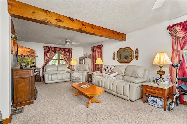 living area with ceiling fan, a textured ceiling, beamed ceiling, and light colored carpet