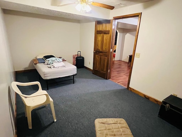 interior space with a ceiling fan, dark carpet, and baseboards