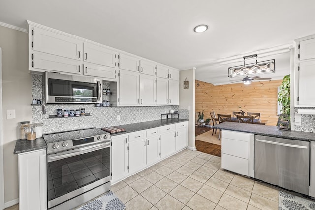 kitchen featuring dark countertops, white cabinetry, and appliances with stainless steel finishes