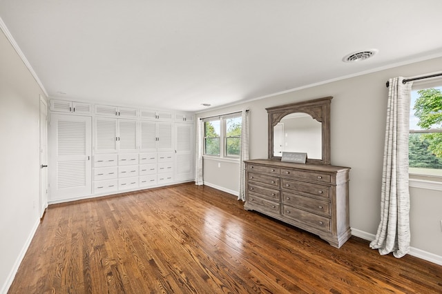 unfurnished bedroom with ornamental molding, dark wood-style flooring, and baseboards