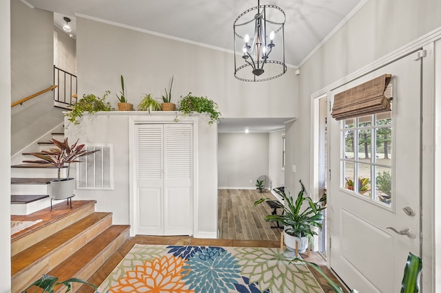 foyer entrance featuring stairway, wood finished floors, and ornamental molding