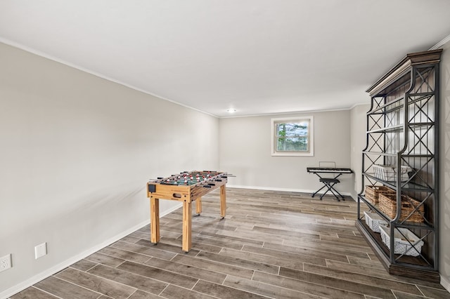 game room featuring crown molding, baseboards, and dark wood-type flooring