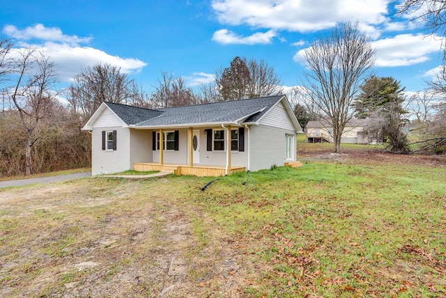 single story home featuring a shingled roof, covered porch, brick siding, and a front lawn