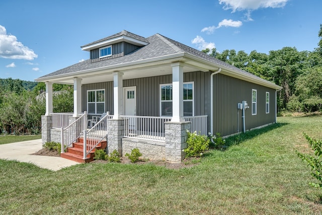 view of front of house with a front yard, covered porch, and roof with shingles