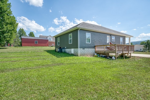 rear view of house with a deck and a lawn