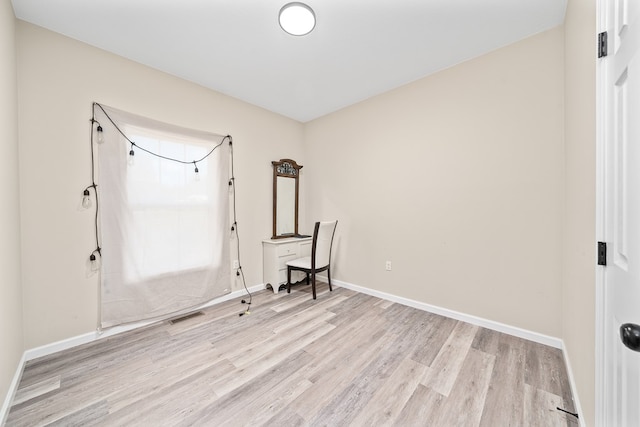 interior space featuring visible vents, light wood-style flooring, and baseboards