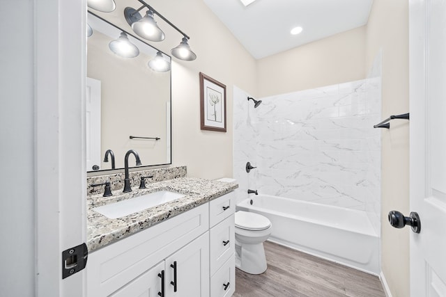 bathroom with toilet, washtub / shower combination, wood finished floors, and vanity