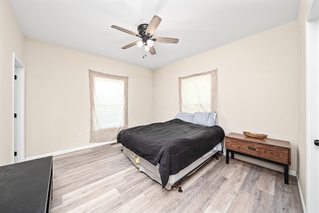 bedroom featuring light wood-style flooring, baseboards, and ceiling fan