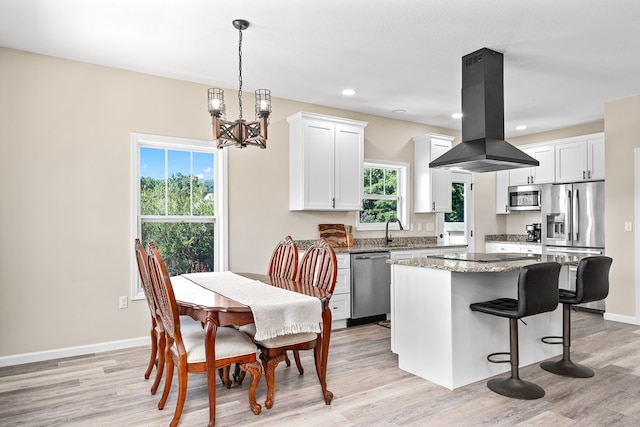 kitchen featuring a kitchen island, island exhaust hood, appliances with stainless steel finishes, and white cabinets