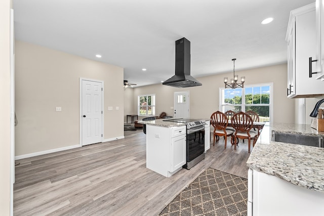 kitchen featuring a kitchen island, hanging light fixtures, island exhaust hood, stainless steel range with electric cooktop, and white cabinetry