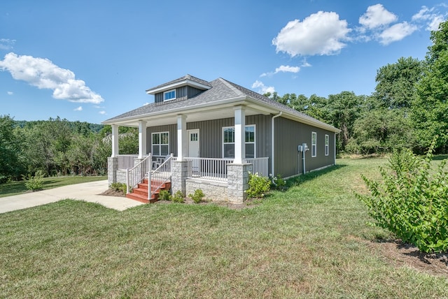 view of front of house with a porch, a front yard, and roof with shingles